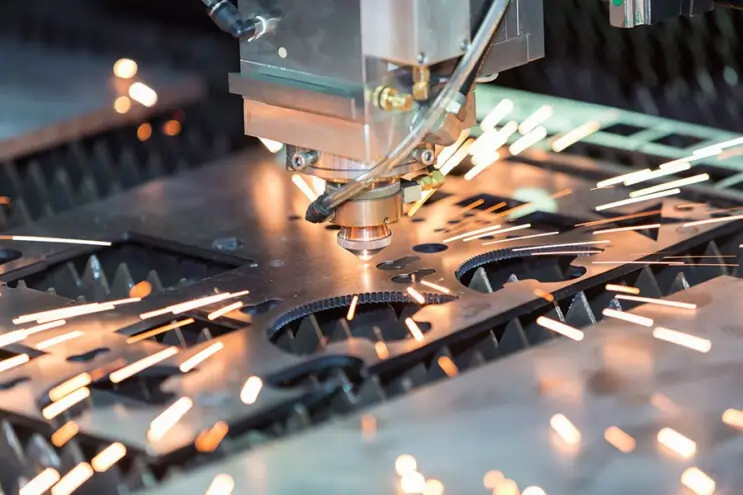 High-speed laser cutting machine processing sheet metal parts with precision and bright sparks