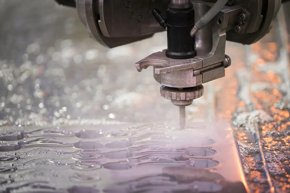 Close-up of a water jet cutting machine in action, precision machining metal with water spray.