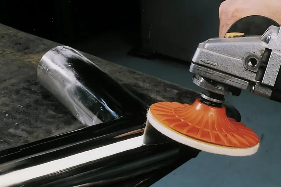 Worker using rotary tool for polishing a metal surface to a glossy finish